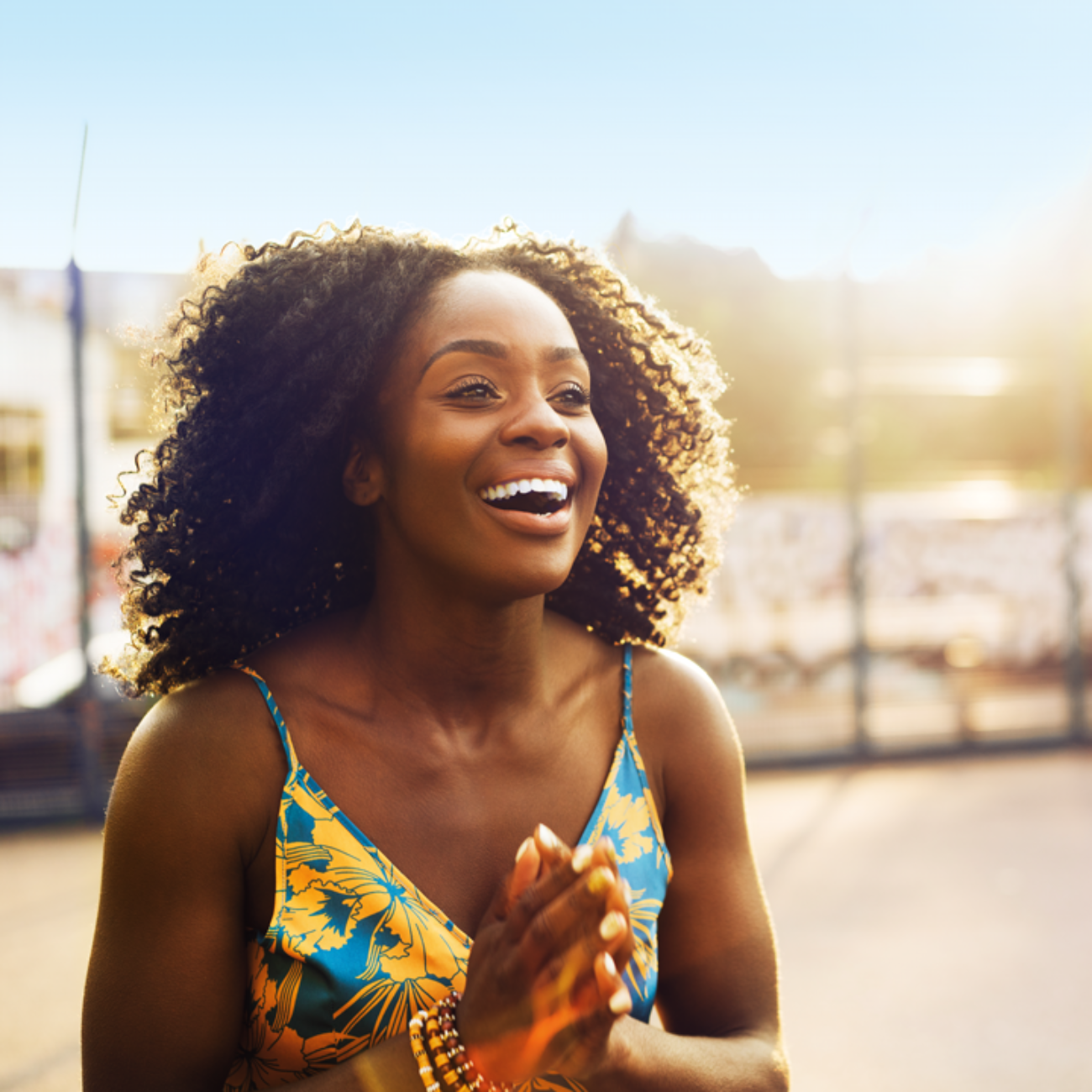 Une femme se tenant debout avec un air joyeux, les mains jointes