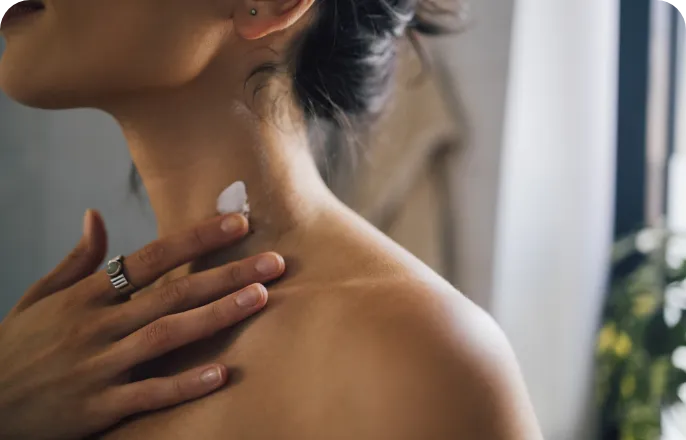 Close-up of a man's shoulder as she applies a bit of cream.