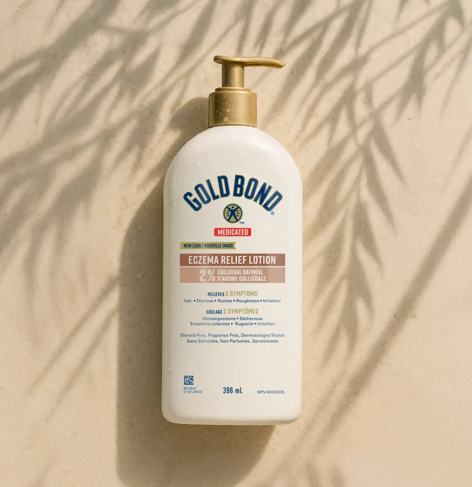 A hand squeezing Gold Bond Age Renew Crepe Corrector Body Lotion, with visible white cream on the other hand. 