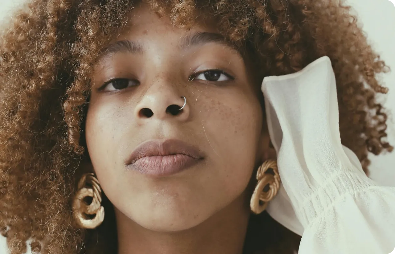 Close-up of a woman's shoulder as she applies a bit of cream.