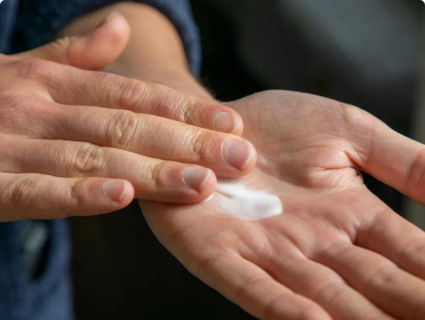 Close-up of hands as they apply a bit of cream.